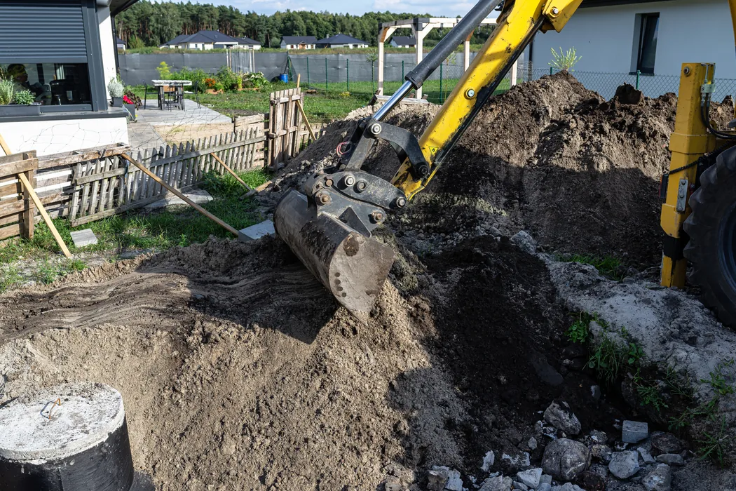 Excavator digging beside a septic tank