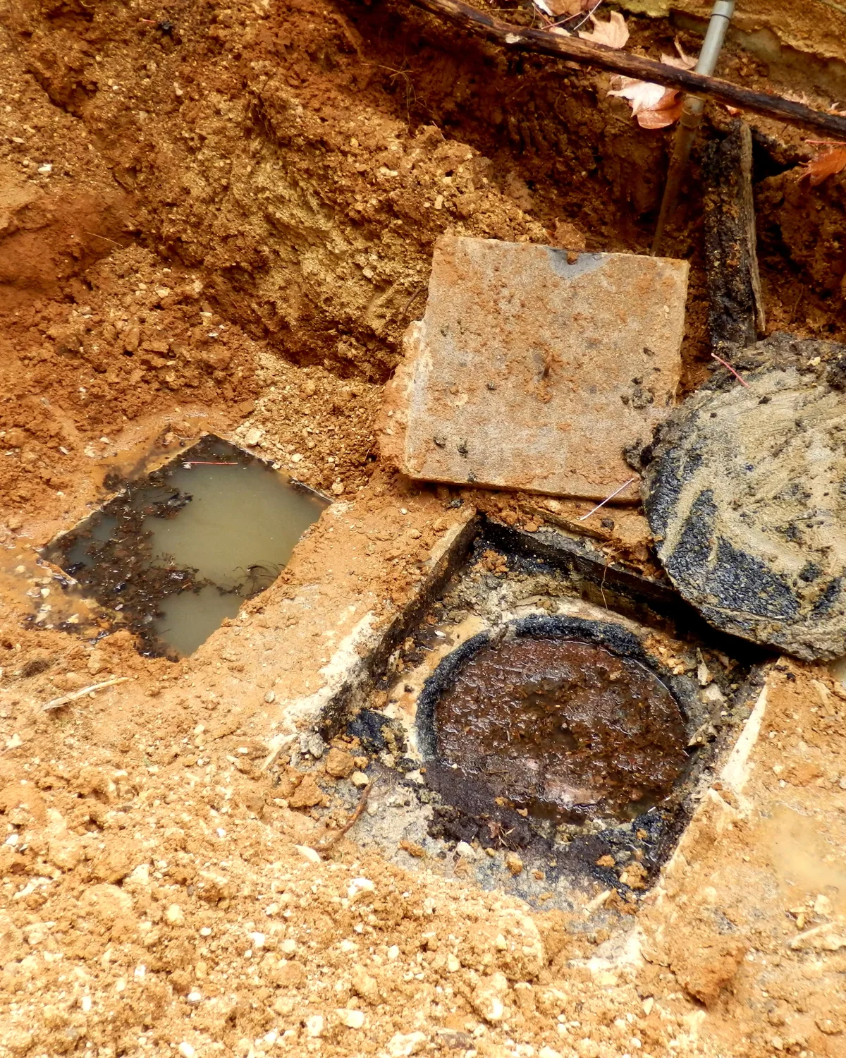 Septic tank hatches opened up for an inspection in red clay